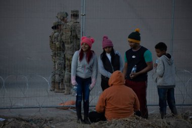Juarez, Mexico, 07-01-2023: Migrants wait in front of a fence that the Texan National Guard placed on the edge of the Rio Grande to prevent the passage of migrants.