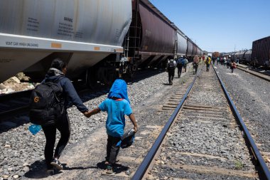 Hundreds of migrants arrive by train to Ciudad Juarez, Mexico, ready to cross the border into the United States in search of a better life. (05/13/23) clipart