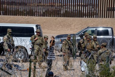 Teksas Ulusal Muhafız Birliklerinin önünde elini kaldıran bir adam Meksika-ABD sınırını geçtikten sonra, Juarez, Chihuahua, Meksika, 02102023.