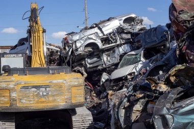 Birkaç araba Meksika 'daki bir hurdalıkta vinç tarafından hurda olarak satılıp geri dönüşüm fabrikasında hurda olarak satılıyor..