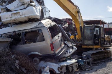 Birkaç araba Meksika 'daki bir hurdalıkta vinç tarafından hurda olarak satılıp geri dönüşüm fabrikasında hurda olarak satılıyor..