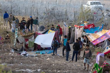 Rio Grande boyunca yüzlerce göçmen kampı, Meksika ve ABD arasındaki doğal sınır. İnsanlar, Teksas Ulusal Muhafız Teşkilatı tarafından fark edilmeden ABD topraklarına girmek için bekliyor..