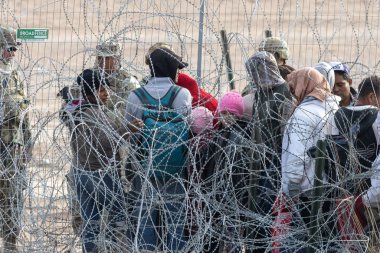 Yüzlerce göçmen, insani sığınma talebinde bulunmak umuduyla ABD-Meksika sınırındaki Teksas Ulusal Muhafız Teşkilatı tarafından fark edilmeden geçmeyi bekliyor..
