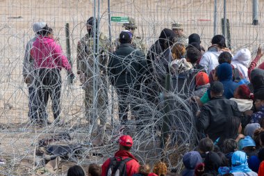 Yüzlerce göçmen, insani sığınma talebinde bulunmak umuduyla ABD-Meksika sınırındaki Teksas Ulusal Muhafız Teşkilatı tarafından fark edilmeden geçmeyi bekliyor..