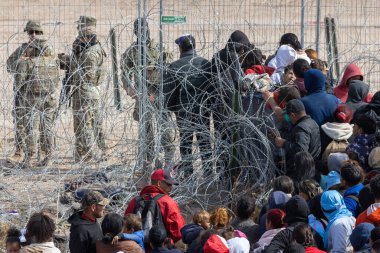 Yüzlerce göçmen, insani sığınma talebinde bulunmak umuduyla ABD-Meksika sınırındaki Teksas Ulusal Muhafız Teşkilatı tarafından fark edilmeden geçmeyi bekliyor..