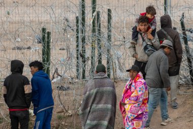 Yüzlerce göçmen, insani sığınma talebinde bulunmak umuduyla ABD-Meksika sınırındaki Teksas Ulusal Muhafız Teşkilatı tarafından fark edilmeden geçmeyi bekliyor..