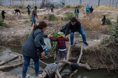 Yüzlerce göçmen, insani sığınma talebinde bulunmak umuduyla ABD-Meksika sınırındaki Teksas Ulusal Muhafız Teşkilatı tarafından fark edilmeden geçmeyi bekliyor..