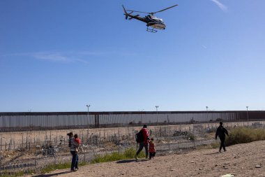Yüzlerce göçmen, insani sığınma talebinde bulunmak umuduyla ABD-Meksika sınırındaki Teksas Ulusal Muhafız Teşkilatı tarafından fark edilmeden geçmeyi bekliyor..