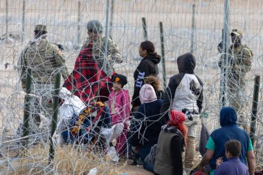 Yüzlerce göçmen, insani sığınma talebinde bulunmak umuduyla ABD-Meksika sınırındaki Teksas Ulusal Muhafız Teşkilatı tarafından fark edilmeden geçmeyi bekliyor..