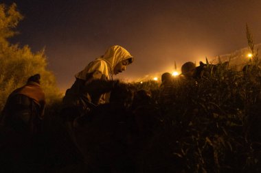 Yüzlerce göçmen, insani sığınma talebinde bulunmak umuduyla ABD-Meksika sınırındaki Teksas Ulusal Muhafız Teşkilatı tarafından fark edilmeden geçmeyi bekliyor..