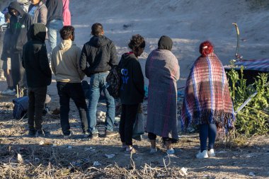 Yüzlerce göçmen, insani sığınma talebinde bulunmak umuduyla ABD-Meksika sınırındaki Teksas Ulusal Muhafız Teşkilatı tarafından fark edilmeden geçmeyi bekliyor..