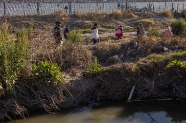 Yüzlerce göçmen, insani sığınma talebinde bulunmak umuduyla ABD-Meksika sınırındaki Teksas Ulusal Muhafız Teşkilatı tarafından fark edilmeden geçmeyi bekliyor..
