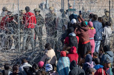 Yüzlerce göçmen, insani sığınma talebinde bulunmak umuduyla ABD-Meksika sınırındaki Teksas Ulusal Muhafız Teşkilatı tarafından fark edilmeden geçmeyi bekliyor..