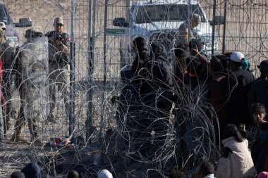 Yüzlerce göçmen, insani sığınma talebinde bulunmak umuduyla ABD-Meksika sınırındaki Teksas Ulusal Muhafız Teşkilatı tarafından fark edilmeden geçmeyi bekliyor..