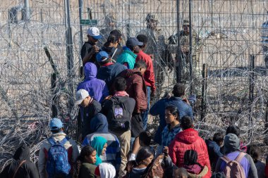 Yüzlerce göçmen, insani sığınma talebinde bulunmak umuduyla ABD-Meksika sınırındaki Teksas Ulusal Muhafız Teşkilatı tarafından fark edilmeden geçmeyi bekliyor..
