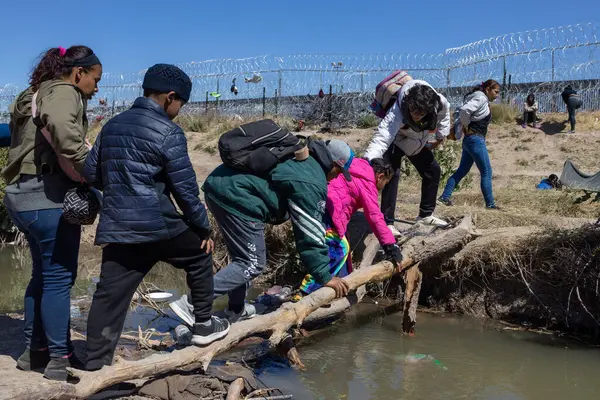 Yüzlerce göçmen, insani sığınma talebinde bulunmak umuduyla ABD-Meksika sınırındaki Teksas Ulusal Muhafız Teşkilatı tarafından fark edilmeden geçmeyi bekliyor..