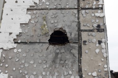 Bina cephesinin yakından bakınca geniş çaplı çarpışma hasarı görülüyor. Büyük bir çukur ve yüzeye saçılmış sayısız küçük kırışıklık da dahil.