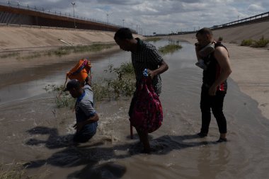 Göçmenler düzensiz bir geçiş sırasında ABD-Meksika sınırındaki bir sınır çitinin yakınından Rio Grande 'ye doğru yürüdüler.