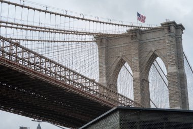 Alacakaranlıkta Iconic Brooklyn Köprüsü 'nde Amerikan bayrağı bir kulede.