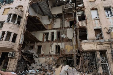 Hasarlı çok katlı yapı, görünen enkazlar ve etkilenmiş yapısal parçalarla savaş yüzünden Ukrayna 'nın bir şehrinde iç yüzünü gözler önüne seriyor..