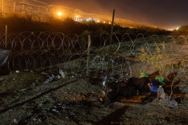 Göçmen Ciudad Juarez 'de dikenli tel örgülerin arkasında dinleniyor. Sınırda karşılaştığımız zorlukları vurguluyor..