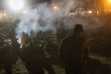 Siviller gece dumanlı Ciudad Juarez sınırında toplanıp geçiş yolu arıyorlar..