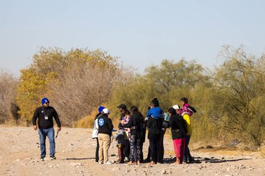 Çocuklar da dahil olmak üzere siviller Ciudad Juarez yakınlarındaki işçilerden yardım alıyorlar..