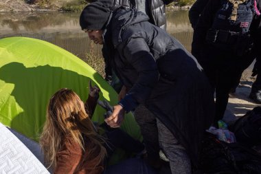 Ciudad Juarez nehir kıyısındaki göçmen kadına yardım ediyor..