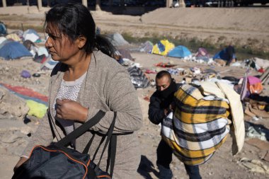 İnsanlar gerekli şeyleri Ciudad Juarez yakınlarındaki bir göçmen kampında taşıyorlar..