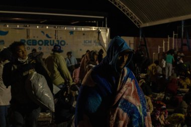 Göçmenler bir Ciudad Juarez barınağında battaniyelerin içinde bekliyorlar..