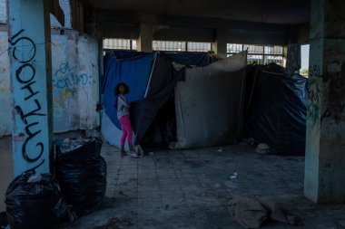 Ciudad Juarez sınırındaki bir binanın yakınındaki barınaklarda yaşayan genç kız, kentsel göçün ve yoksulluğun acı gerçeklerini simgeliyor..