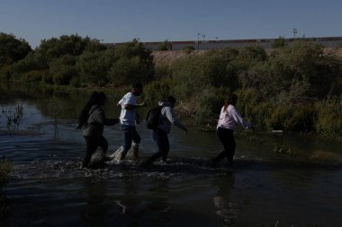 Göçmenler Ciudad Juarez sınır çitinin oradaki suda geziniyorlar..