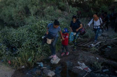 Ciudad Juarez 'deki göçmenler geçici bir köprüde yol alıyorlar, güvenliği sağlamak için zor koşullara katlanıyorlar..