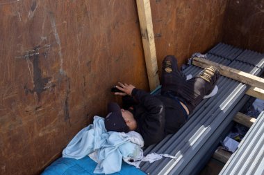 Bir göçmen, Ciudad Juarez sınırındaki geçici bir sığınakta dinleniyor. Sığınak ve umut arıyor..