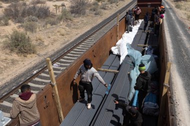 Göçmenler daha güvenli geçiş için Ciudad Juarez yakınlarındaki çölde yük trenine biniyorlar..