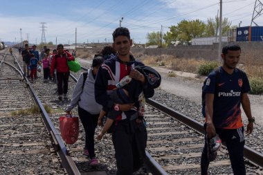 Göçmenler Ciudad Juarez yakınlarında demiryolu hattından geçerek sığınak arıyorlar..