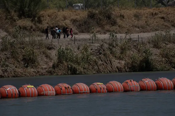 Ciudad Juarez 'deki Rio Grande' nin yanından geçen göçmenler, geçişleri engelleyen engellerle dolu..
