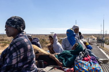 Ciudad Juarez yakınlarındaki seyrek çöl arazisinden geçen göçmenler düzensiz bir geçiş için Rio Grande 'ye yaklaşıyorlar..