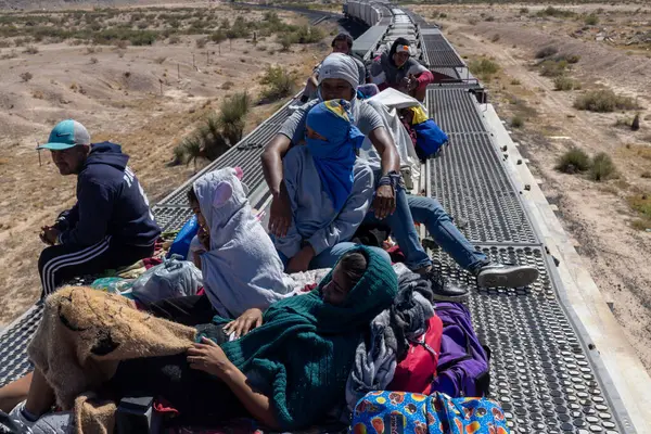 Ciudad Juarez yakınlarındaki bir yük treninin tepesindeki göçmenler, yeni bir hayat için tehlikeli yolculukların simgesi..