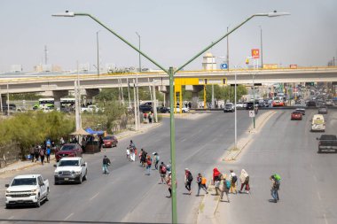 Ciudad Juarez sınırı yakınlarındaki grup karşıya geçiyor, göç sorunlarını vurguluyor.