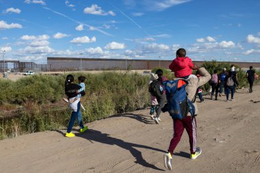 Göçmenler Ciudad Juarez 'in sınır duvarına yaklaşıyorlar. Uçsuz bucaksız gökyüzünün altında umut ve mücadeleyi simgeliyorlar..