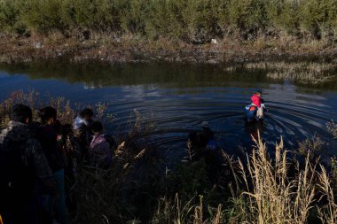 Göçmenler Ciudad Juarez yakınlarındaki bir nehri geçerek tehlikeli yollarındaki doğal engelleri aşıyorlar..