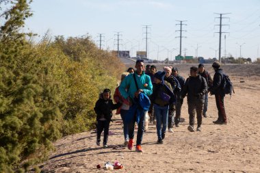 Ciudad Juarez 'in tozlu yolunda yürüyen göçmenler..
