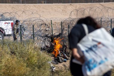 Bir güvenlik görevlisi Ciudad Juarez yakınlarındaki bir sınır bölgesini gözlüyor. Orada küçük bir yangın çıkıyor ve dikenli teller yolu kapatıyor. Bir göçmen ihtiyatlı bir şekilde ilerliyor..