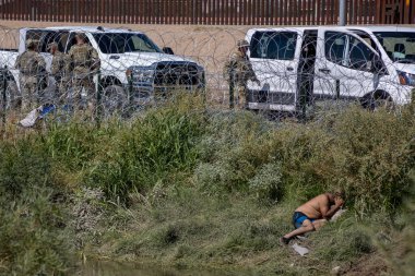 Rio Grande 'de, Ciudad Juarez' de dikenli tellerin arkasından Amerikan askeri gözlemcisi olarak dinlenen bir adam var..