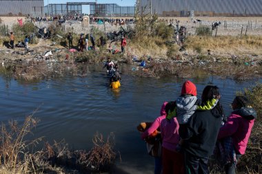 Aileler ve çocuklar daha güvenli topraklar aramak için Ciudad Juarez yakınlarındaki Rio Grande 'de geziniyorlar..