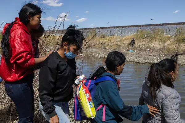 Sırt çantalı göçmenler, Ciudad Juarez yakınlarındaki Rio Grande boyunca korunan sınır çitlerinin yanında toplandılar..