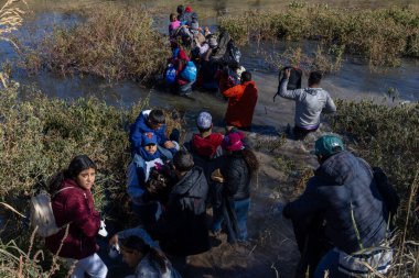 Göçmenler, Amerika Birleşik Devletleri 'ne girerken yanlarında eşyalarını taşıyarak Ciudad Juarez' deki Rio Grande 'den geçtiler..
