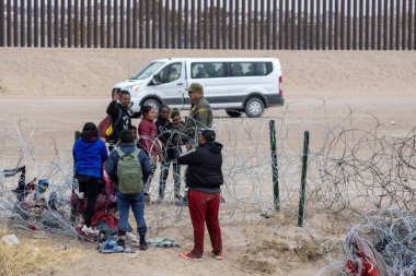 Siviller, güçlendirilmiş Ciudad Juarez sınır kapısında bir sınır ajanıyla görüşüyor..
