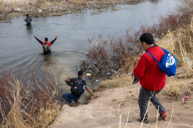 Göçmenler Ciudad Juarez yakınlarında sığ bir nehirden geçerek sığınak arıyorlar..